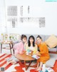 A group of women sitting around a table on a couch.