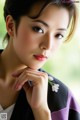 A woman in a kimono with a flower in her hair.